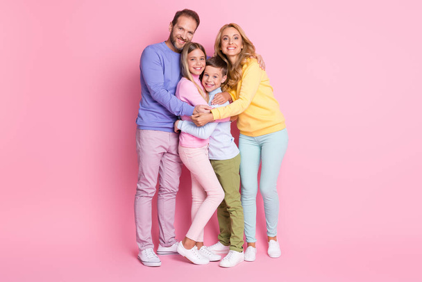 Full size photo of positive cheerful family daddy mommy hug little boy girl isolated over pastel color background - Foto, afbeelding