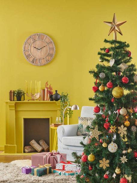 Quarto interior amarelo decorativo com árvore de Natal, lareira, relógio e poltrona azul. Feliz ano novo conceito. - Foto, Imagem
