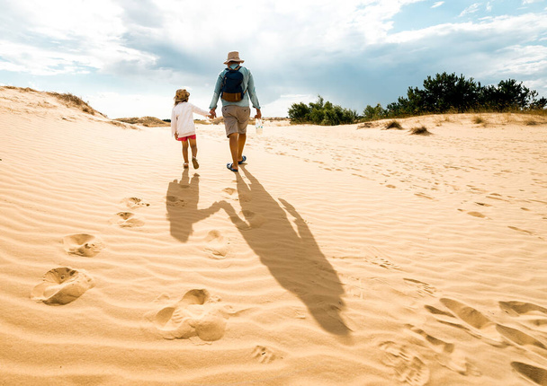砂漠の娘と父。Oleshkyサンズ、ヘルソン地域、ウクライナの砂漠の砂丘の美しいテクスチャ。ヨーロッパ最大の砂漠. - 写真・画像