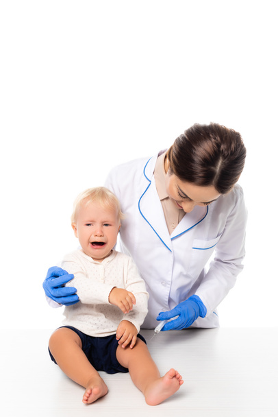 Lääkäri tilalla ruisku lähellä itkevä lapsi poika eristetty valkoinen - Valokuva, kuva