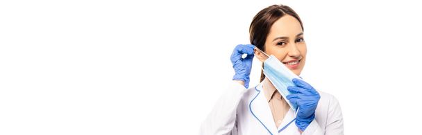 Nagłówek strony internetowej lekarza dodatniego w rękawiczkach lateksowych z maską medyczną izolowaną na biało - Zdjęcie, obraz