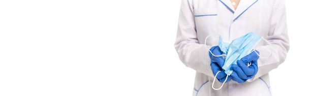 Панорамная ориентация врача, держащего медицинские маски изолированные на белом - Фото, изображение