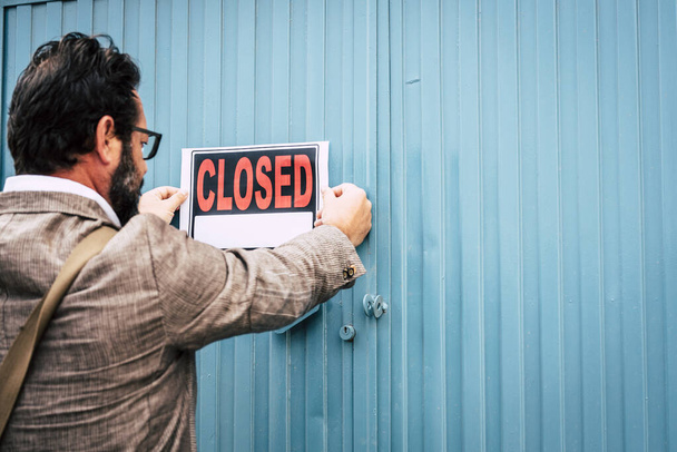 Hombre de negocios fracasado dueño de la tienda con letreros cerrados en la puerta de su tienda - Foto, imagen