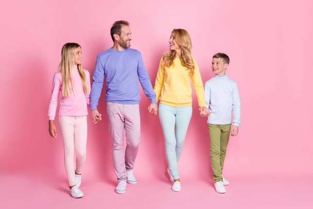Full size photo of positive family dad mom and two little kids hold hands go isolated over pastel color background - Valokuva, kuva