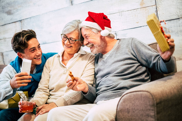 Щаслива сім'я дарує подарунки і ділиться веселощами і сміється один з одним у святковому різдвяному святкуванні вдома
 - Фото, зображення