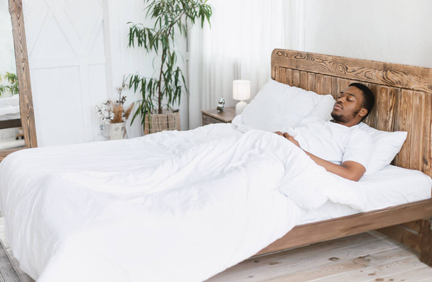 African Man Śpiący Leżący z oczami zamkniętymi w łóżku - Zdjęcie, obraz