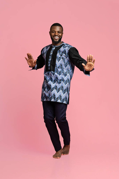 Bouncy african guy dancing over pink background - Photo, Image