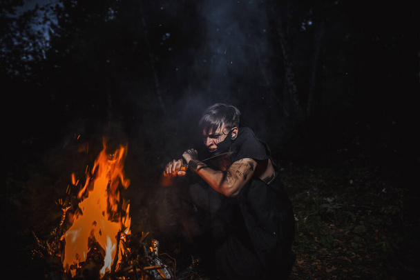 Чаклун зі слідами на своєму тілі в лісі
 - Фото, зображення