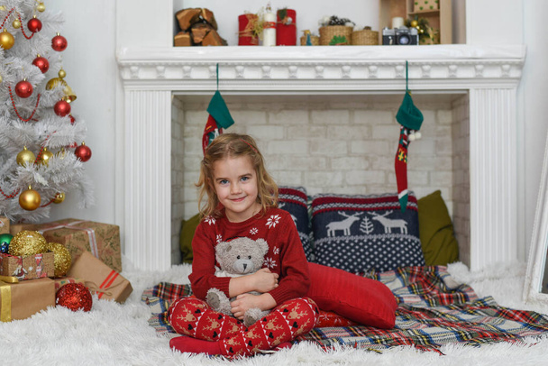 Happy little smiling girl with christmas gift box and teddy bear - Fotoğraf, Görsel