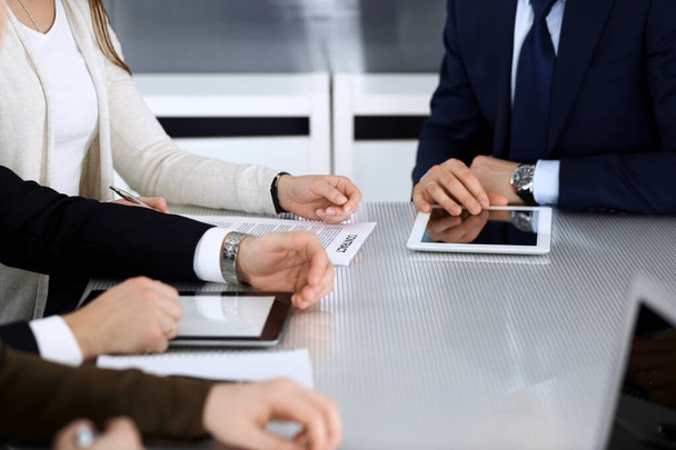 Business people discussing contract working together at meeting at the glass desk in modern office. Unknown businessman and woman with colleagues or lawyers at negotiation. Teamwork and partnership - Foto, Imagem
