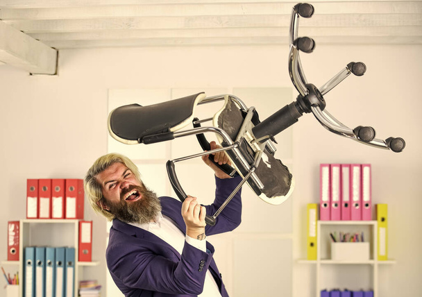 Get rid of the excess. Businessman standing in office hold chair. Stress concept. Crazy or mad. Business man aggressive. Hipster man angry with office chair. Throw out chair. Furniture sale - 写真・画像