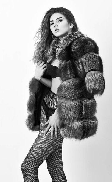 Woman tousled hairstyle posing lingerie and fur jacket. Girl temptress wear stockings and fur coat. Fashion boutique concept. Fashion for female. Elite clothes for sensual girl. Fashion luxury design - Fotoğraf, Görsel