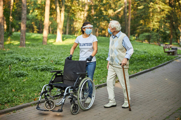 Dorosła radosna kobieta w białej koszuli pomaga starszemu mężczyźnie - Zdjęcie, obraz