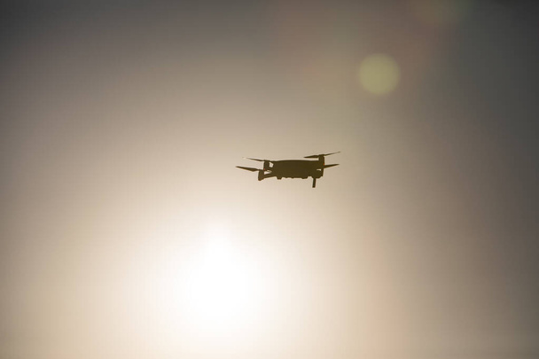 Color image of a drone flying at sunrise. - Fotoğraf, Görsel