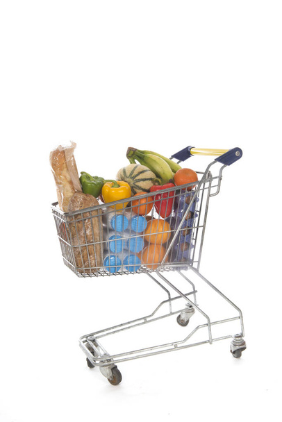 Shopping cart blue and yellow full with fresh groceries - Valokuva, kuva