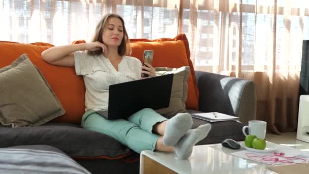 Femme travaille comme influenceur des médias sociaux à la maison smartphone utilisation - Séquence, vidéo