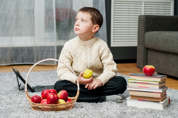 Boy with apples and books  at home - Фото, изображение