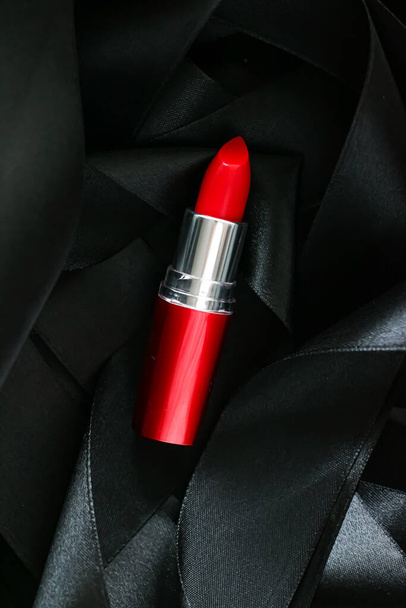 Roter Lippenstift auf schwarzem Seidenhintergrund, luxuriöses Make-up und Schönheitskosmetik - Foto, Bild