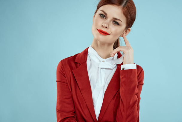 エレガントな女性で赤ジャケット明るいメイク唇自信クロップビュー青の背景 - 写真・画像