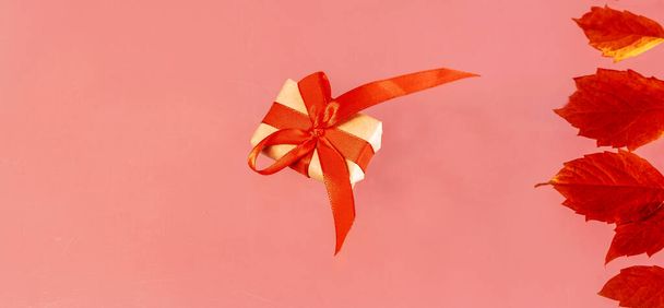 баннер подарочная коробка на розовом фоне с осенью листья праздничной концепции вид сверху копировать пространство для текста настоящее - Фото, изображение