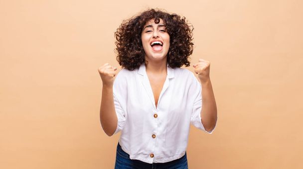 Woman feeling happy, surprised and proud, shouting and celebrating success with a big smile - Photo, image