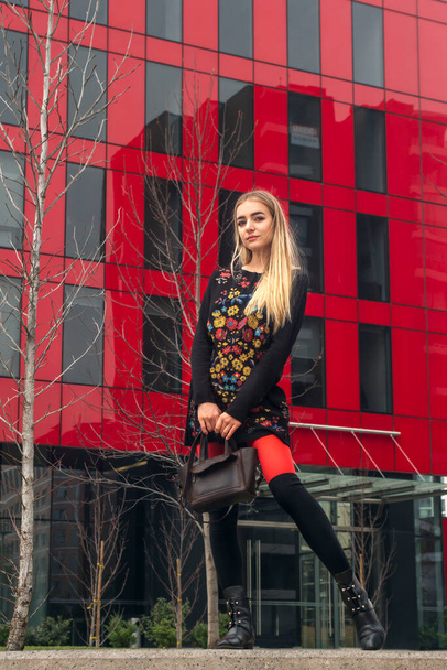 красивая блондинка в красных колготках позирует в городе - Фото, изображение