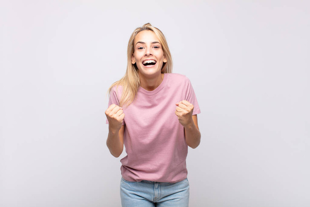 Woman shouting triumphantly, laughing and feeling happy and excited while celebrating success - Photo, Image