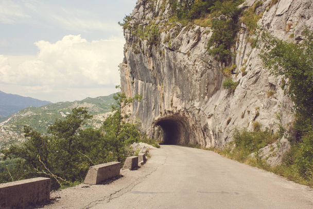 Міцна тверда скеля Вхід до коротких тунельних воріт на дорогу, на гірському шляху в Чорногорії - Фото, зображення