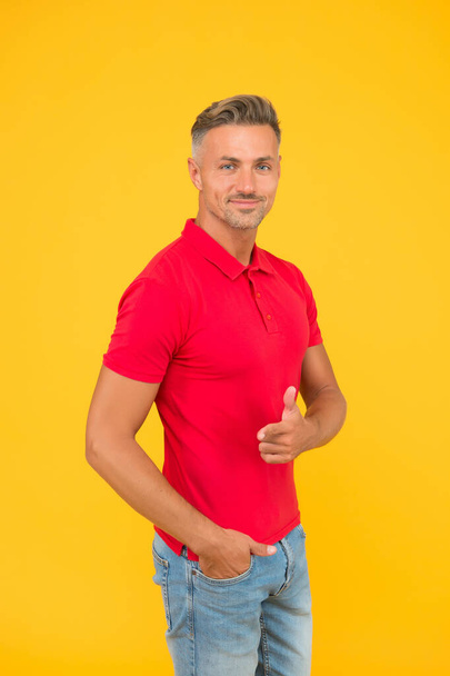 Happy man with stylish beard hair in casual fashion style pointing gun hand gesture yellow background, publicity - Фото, изображение