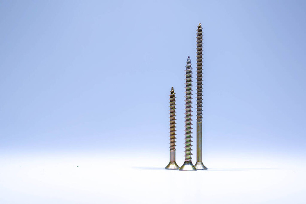 Three construction screws. Imitation of skyscrapers against the sky. - Foto, afbeelding