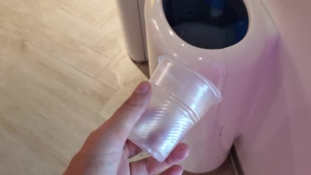 POV arrugarse y tirar taza de plástico desechable en el bote de basura - Metraje, vídeo