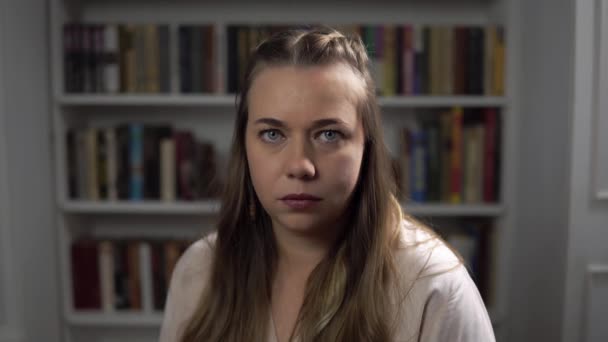 Portret van een jonge blanke vrouw die fronst en een vuist laat zien - Video