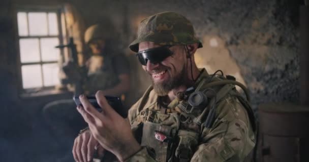 Militaire man met behulp van smartphone in grungy gebouw - Video