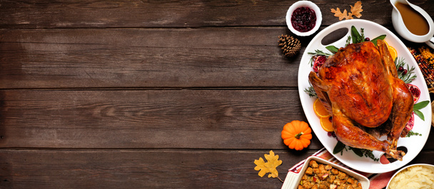 Traditionelles Truthahnessen zu Thanksgiving. Seitenrand aus Overhead-Ansicht auf dunklem Holz-Banner-Hintergrund mit Kopierraum. - Foto, Bild