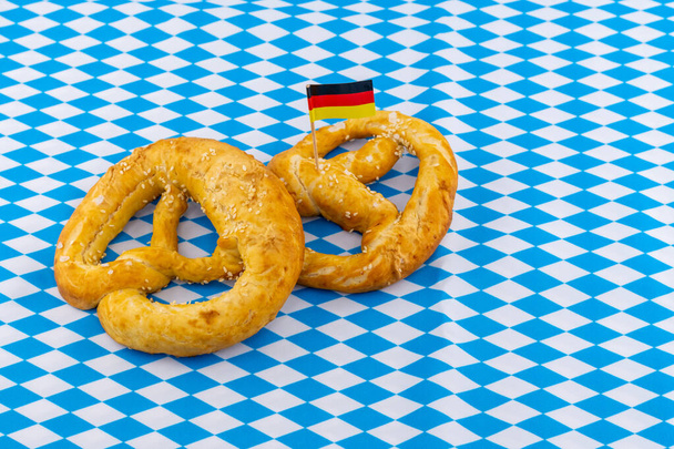 twee briglettes met zout met Duitse vlag op blauw en wit ruitpatroon achtergrond - Foto, afbeelding