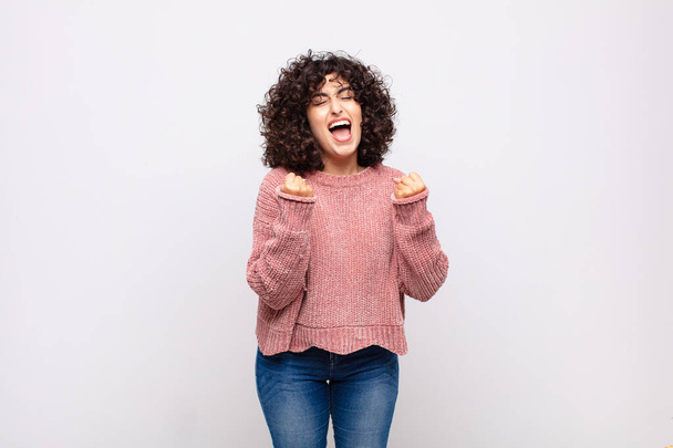 Woman shouting triumphantly, laughing and feeling happy and excited while celebrating success - Foto, Imagen