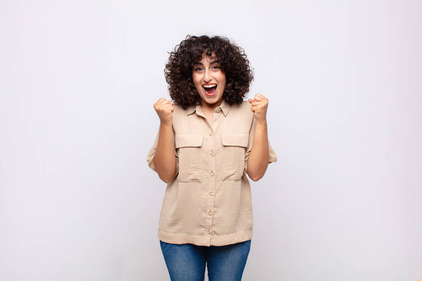 Woman feeling shocked, excited and happy, laughing and celebrating success, saying wow! - Foto, imagen