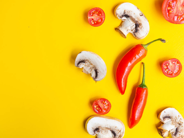Healthy food and dieting concept. Creative layout made of tomato, red pepper and mushroom champignon isolated on yellow color studio background with copy space. Flat lay, view from top. - Foto, Imagen