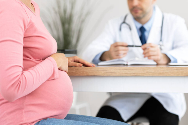 Опытный врач консультирует молодую беременную женщину - Фото, изображение