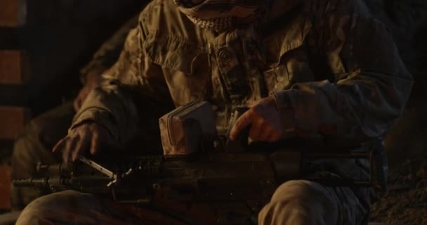 Soldaat verzamelt geweer bij kampvuur - Video