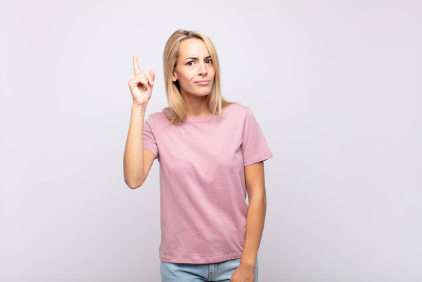 Woman feeling like a genius holding finger proudly up in the air after realizing a great idea, saying eureka - Photo, image