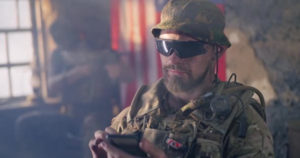 Soldato americano navigando smartphone durante la guerra - Filmati, video