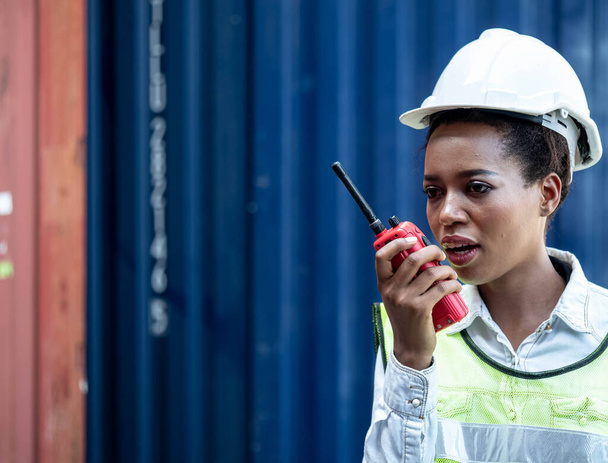 Foreman engineering women african black skin is holding computer notebook pc tablet and talk phone about work at storage container cargo import export investment technology business - Φωτογραφία, εικόνα