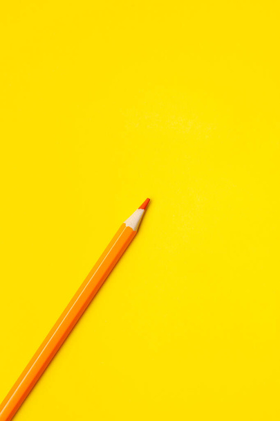 diagonal orange sharp wooden pencil on a bright yellow background, isolated, copy space, mock up - Фото, изображение