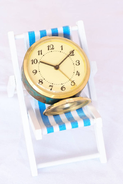 Relógio vintage em uma cadeira de gramado, conceito de tempo de lazer - Foto, Imagem