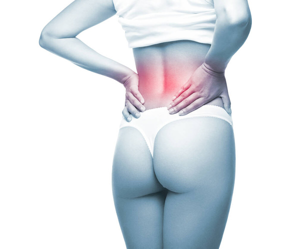 Vrouw met rugpijn, rugletsel, jonge vrouw in ondergoed, verzorging van gezondheid en lichaamsverzorging, op een witte achtergrond - Foto, afbeelding