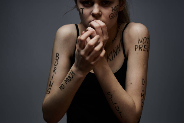 Mujer emocional con inscripciones en sus gestos corporales con las manos estilo de vida frustración estrés fondo gris - Foto, imagen