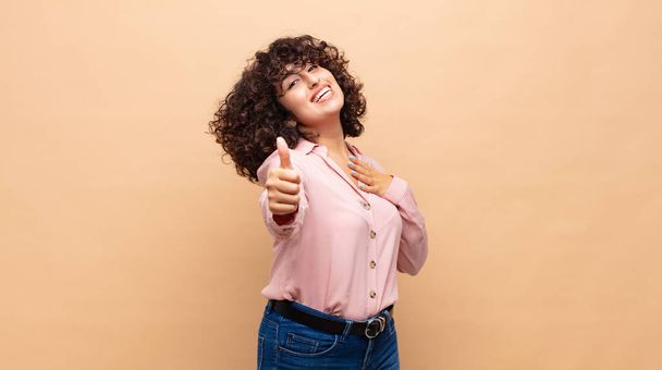 Woman feeling proud, carefree, confident and happy, smiling positively with thumbs up - Fotoğraf, Görsel
