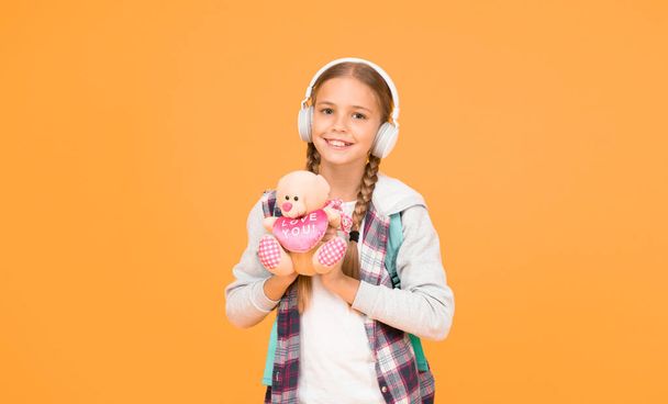 person that cares. hipster girl lpove play with toy. schoolgirl casual style hold bear toy. autumn time for knowledge. child listen music headset. childhood education and development. audio book - Fotografie, Obrázek