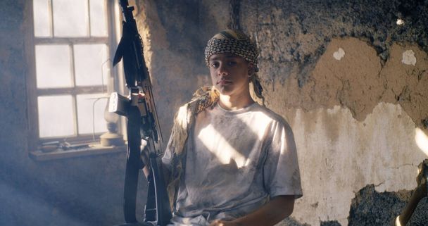 Giovane terrorista con arma in camera squallida - Foto, immagini
